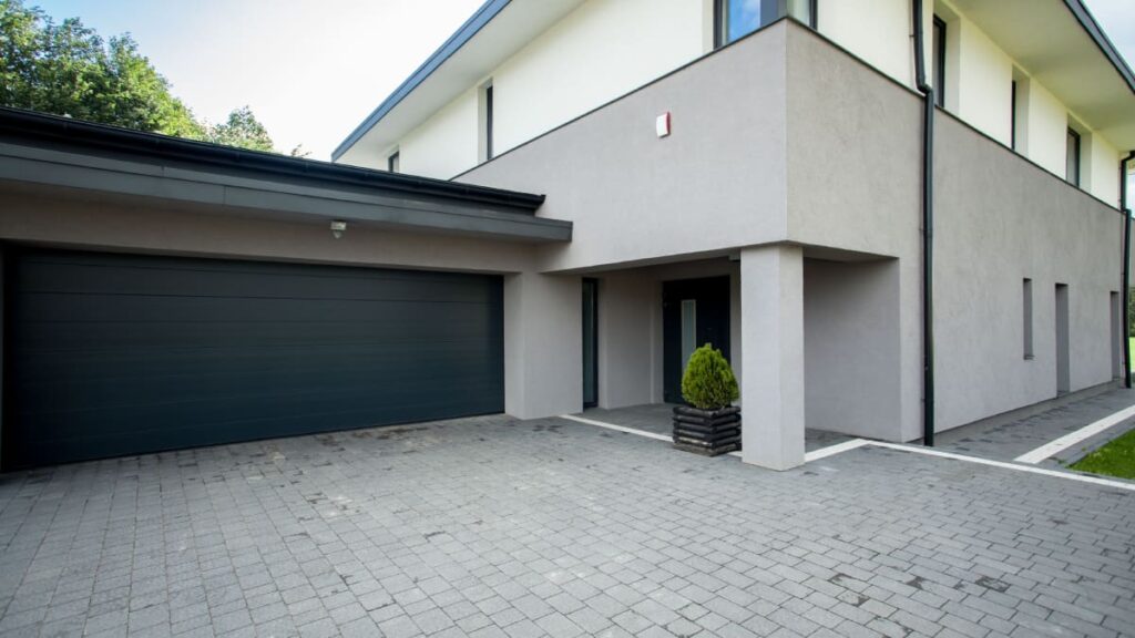 Crepi gevel met betonlook, gecombineerd met een moderne garage.