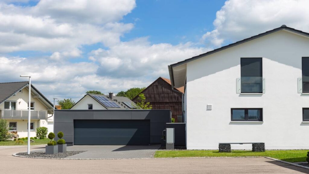 Modern huis met crepi gevelbekleding en een donker gekleurde garage.